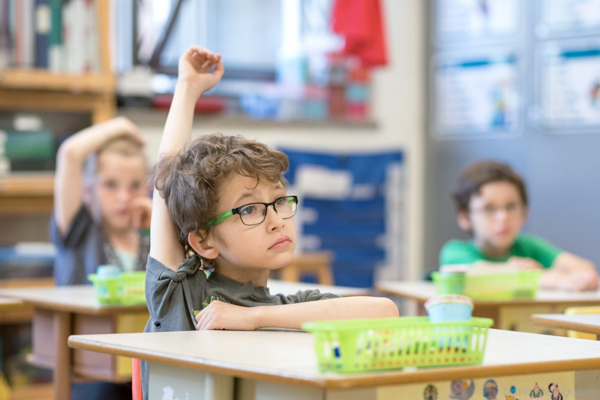 garçon lève la main à l'école
